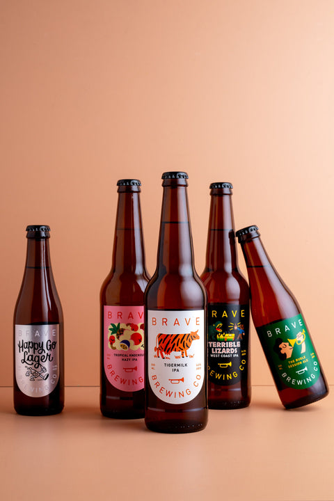 Five bottles of Brave Brewing beer on a peach background
