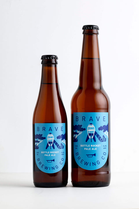 Two bottles of Brave Brewing Co. Bottle Rocket Ale on a white background