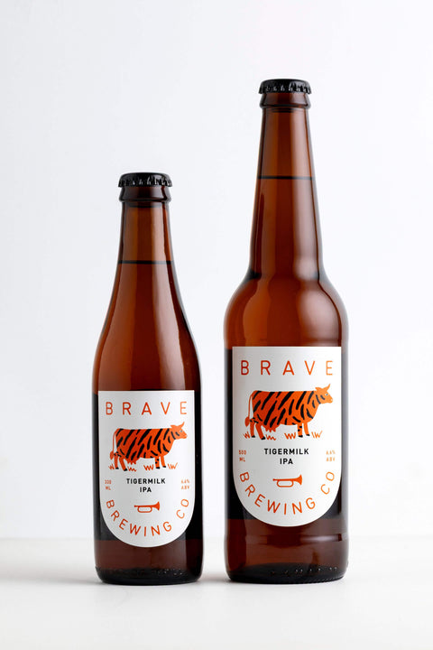 Two brown bottles of Brave Brewing Co. Tiger Milk IPA on a white background