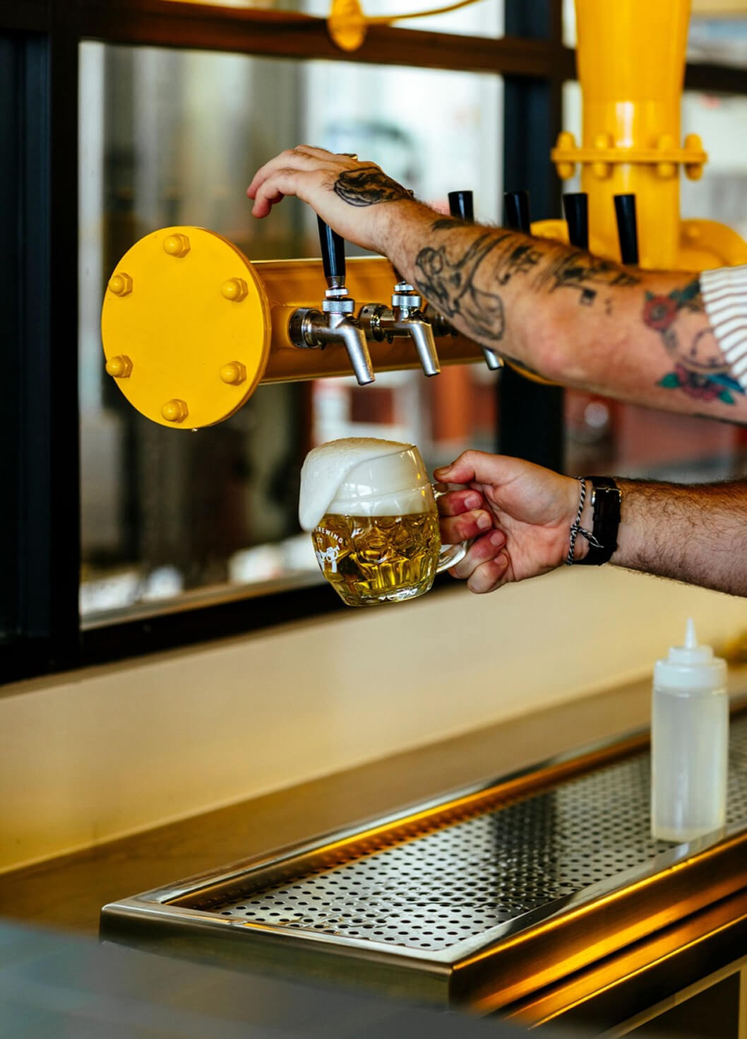 Person pouring beer from a tap into a glass at Brave Brewing Co