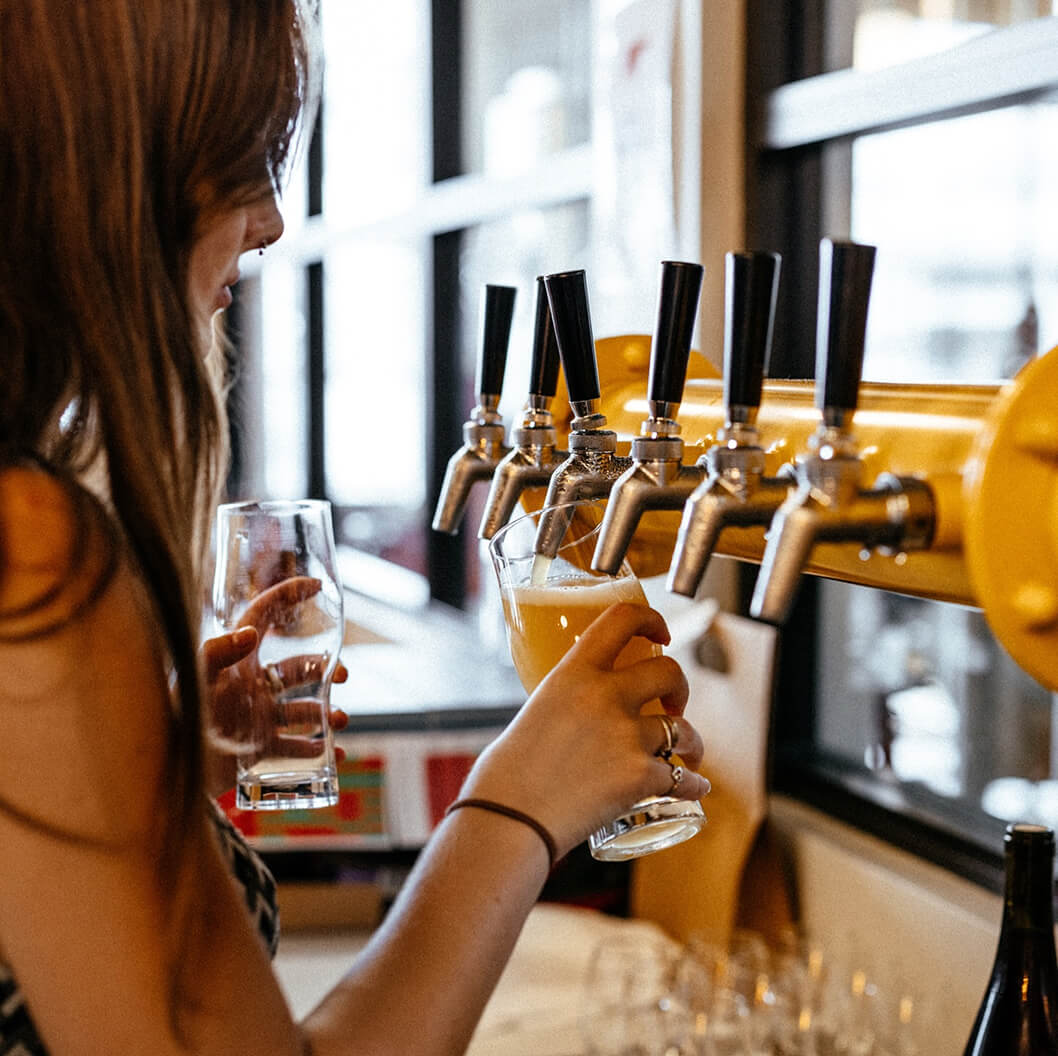 Person pouring beer from a tap into a glass at Brave Brewing Co